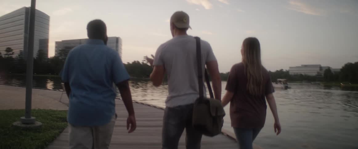 Friends walking on boardwalk along a lake in the city