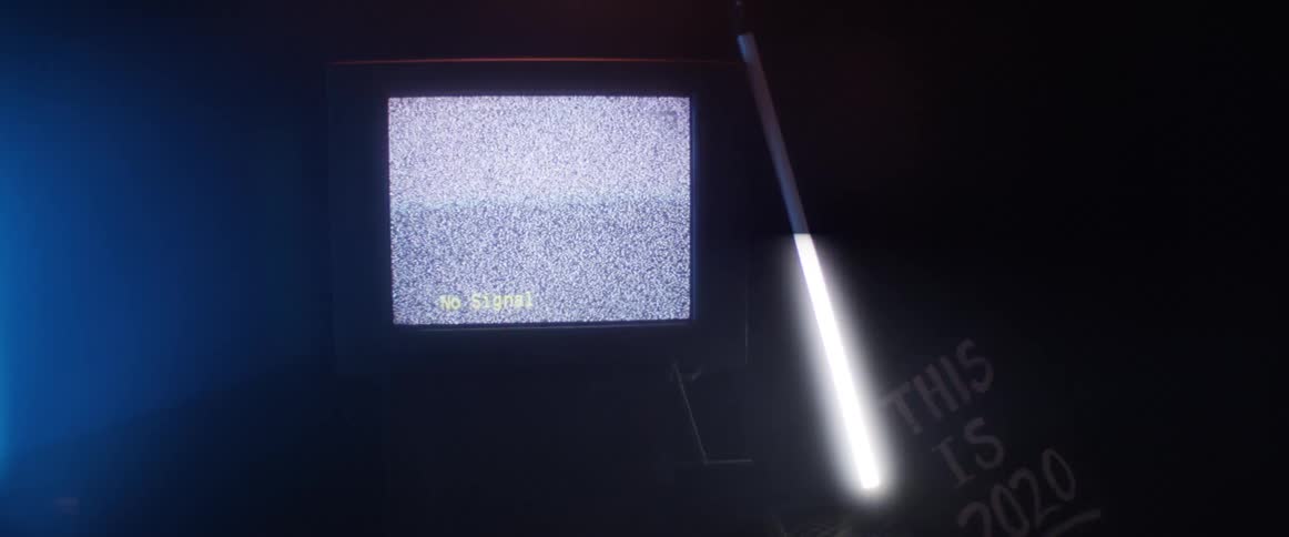 Television with static and flashing fluorescent light in dark room with text this is 2020