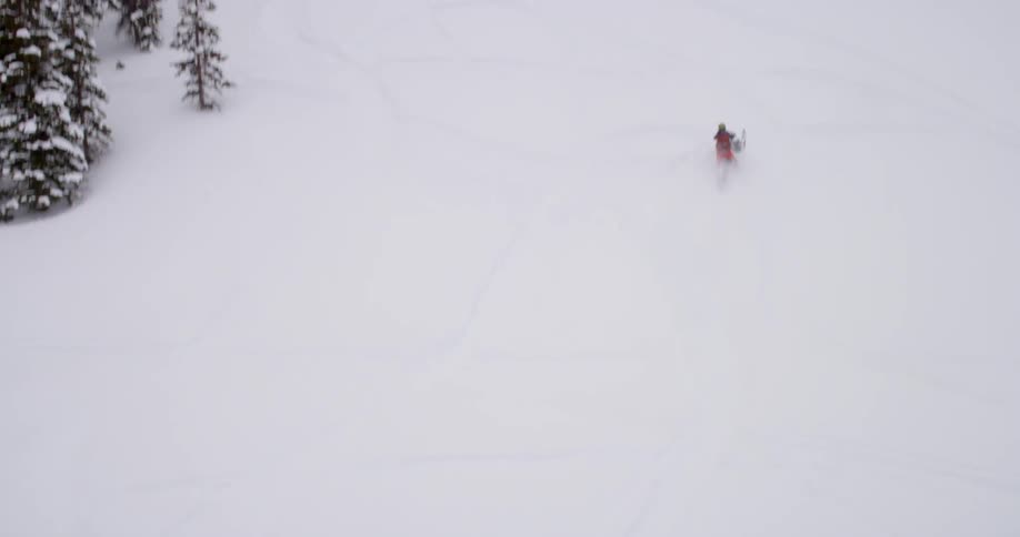A person snowmobiles up a hill