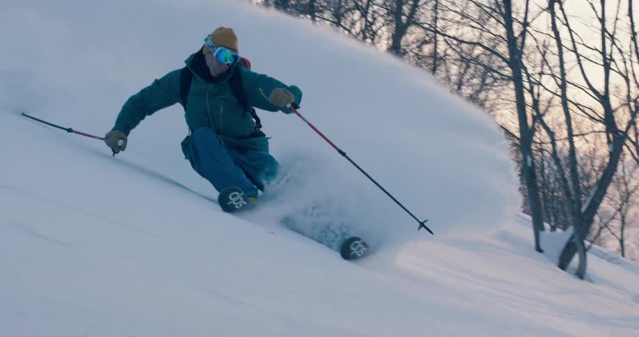 A skier gliding down a snowy mountainside in the winter