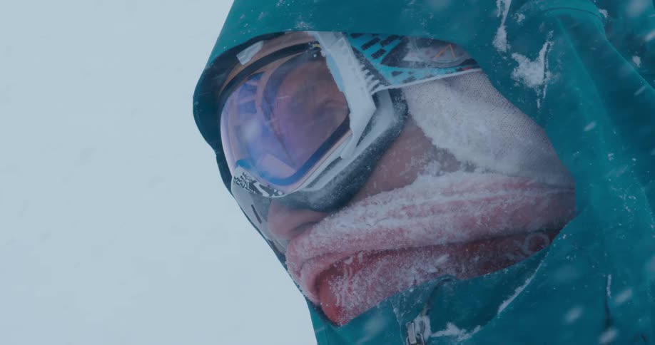 A skier stands still as heavy snowfall falls around him