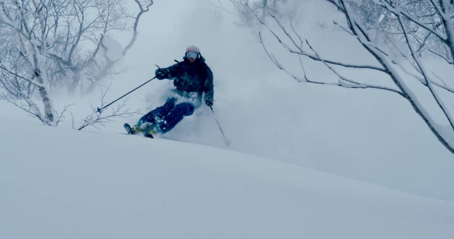 A man is skiing down a hill in winter