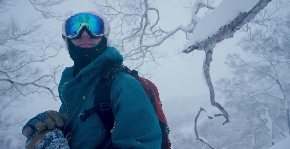 A skier smiles in the forest during a storm