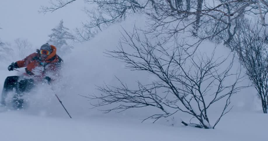 A man is skiing through the snow during the day