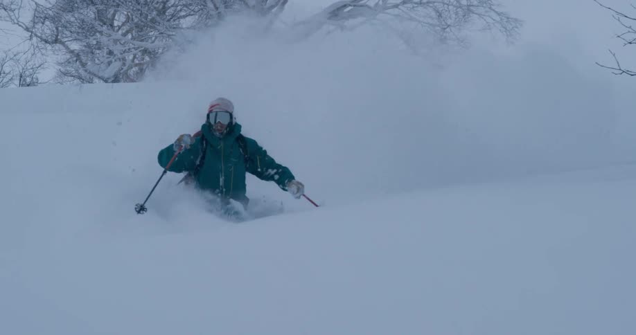 A skier leaves a trail and almost loses his balance as he twists and turns through heavy snow
