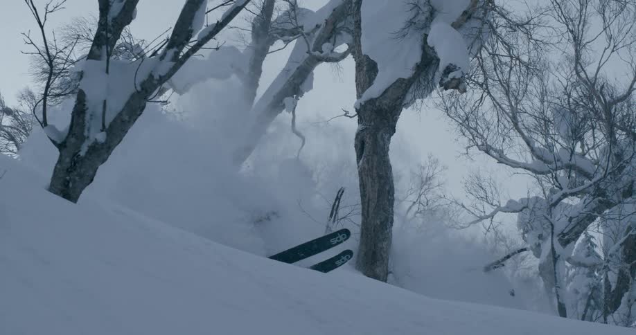 A skier going over a jump in snowy mountains