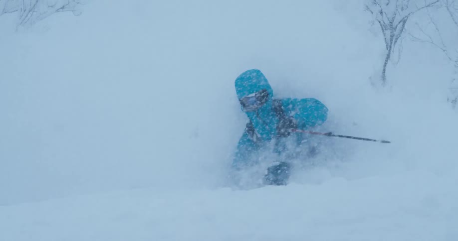 A a skier skiing on a mountain in a blizzard