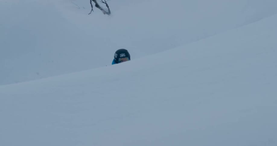 Person skis downhill in deep snow