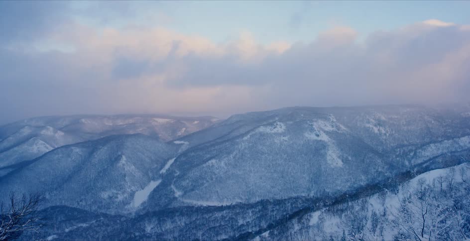 Clouds floating over a snowy mountains landscape on a winter day