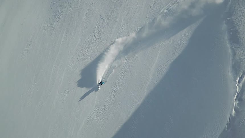 A skier gliding down a snowy mountainside on a winter day