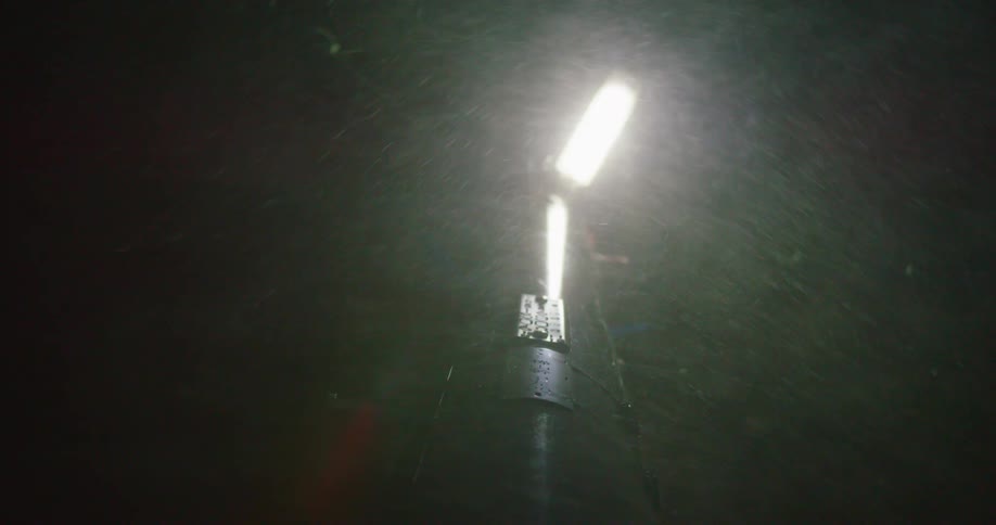 Snow blowing in the wind near a light