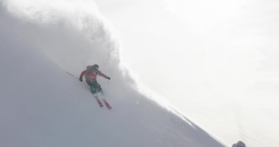 A skier gliding down a snowy mountainside on a winter day