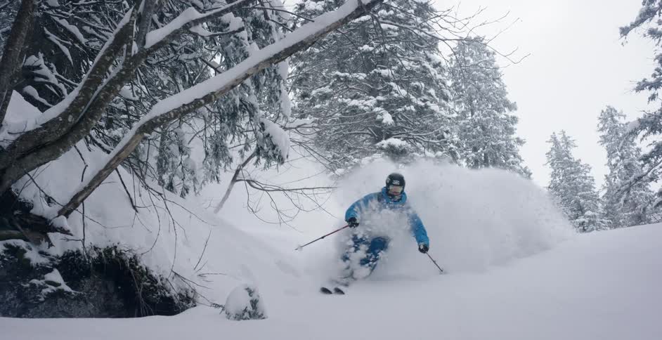 A male skier skiing down a snowy mountain