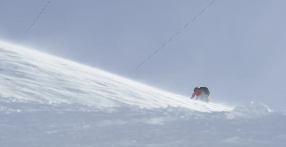 A person is climbing up a snow covered mountain