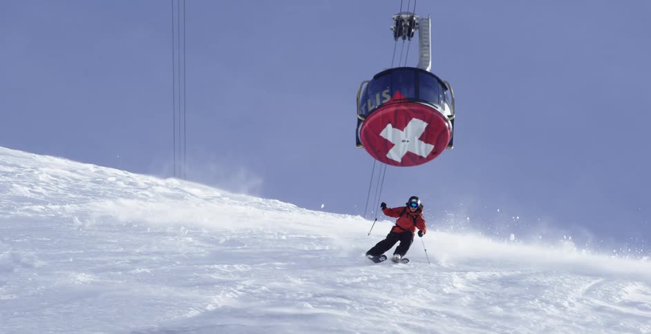 Skier slides down the snow covered slope on a mountain under a ski lift
