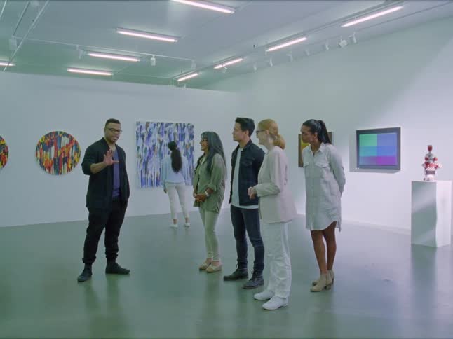 A man talks to a group of people in a museum