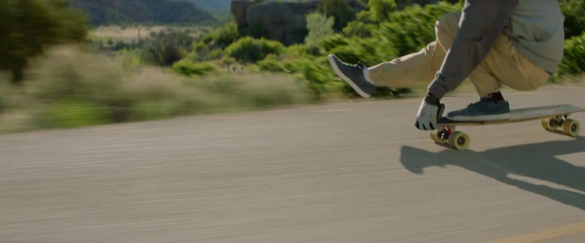 Young person skateboards on empty rural highway