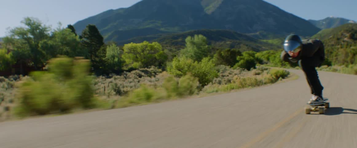 A person is riding a long board down the road