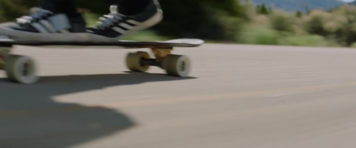 Skateboarders ride on highway at high speed