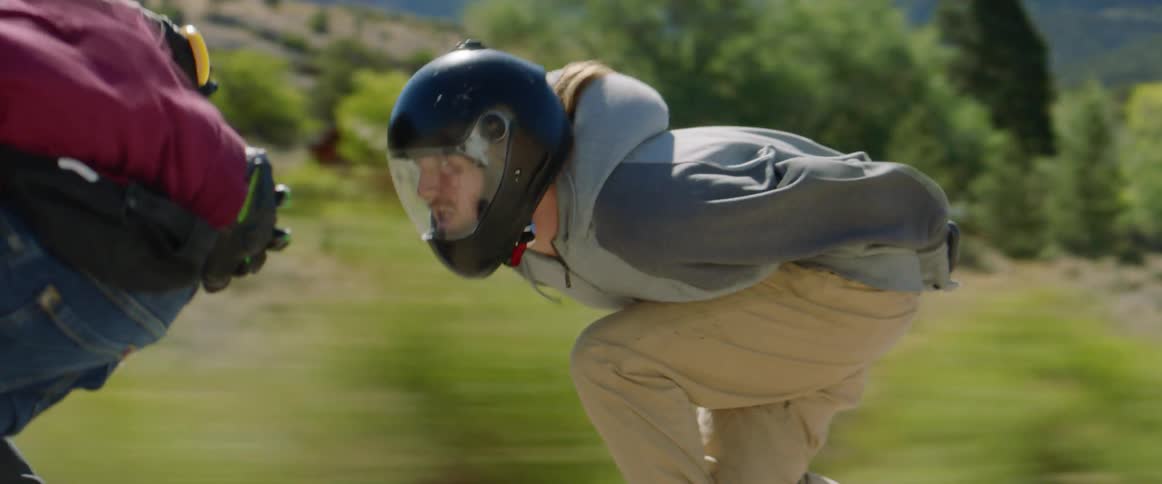 Skateboarders with helmets ride on highway at high speed