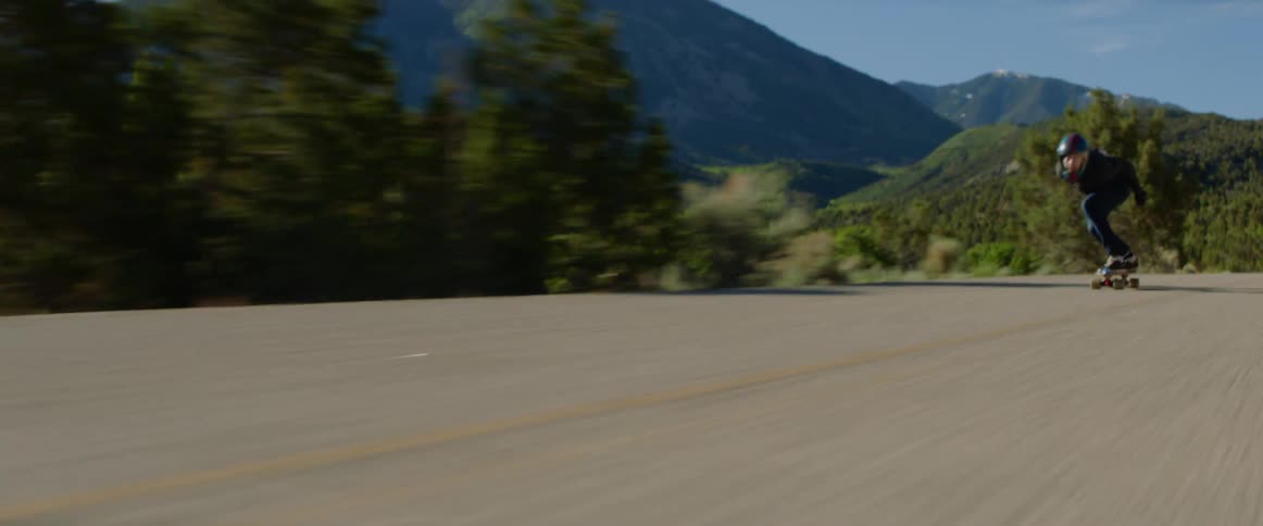 A person skateboards on a rural road