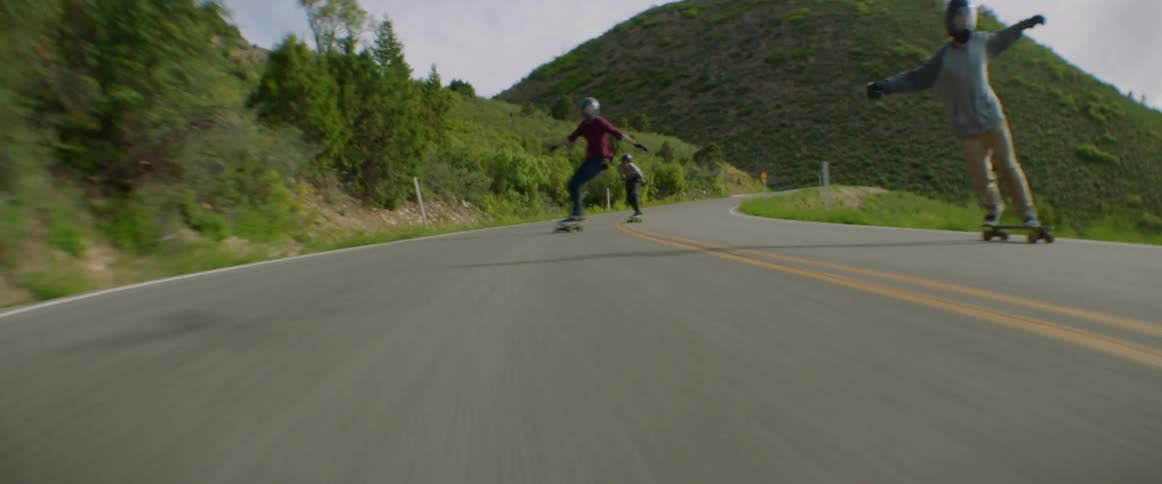 A group of people long boarding down a mountain