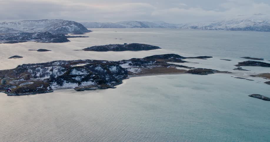 An aerial view of islands off a snowy coast in winter