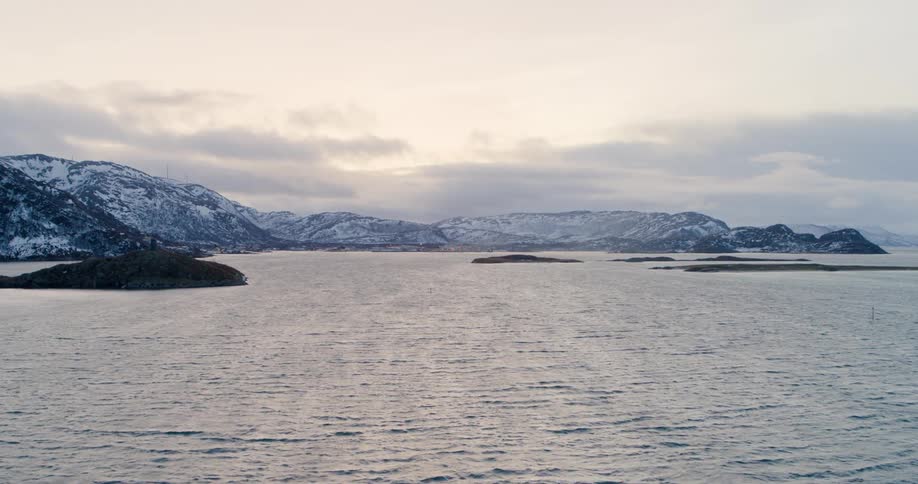 Landscape view of the ocean with snowy hills on the shore