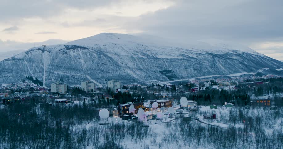 An aerial view of a satellite facility in front of a mountain