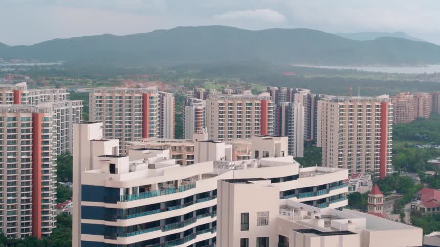 Skyscrapers in a metropolis near a mountain range shrouded in fog