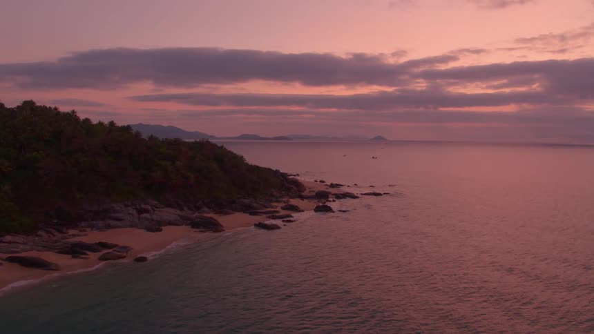 The sun is setting above the ocean in the horizon