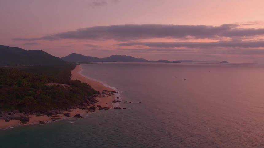 Sun sits behind clouds as fog covers mountains in Hainan, Southern China