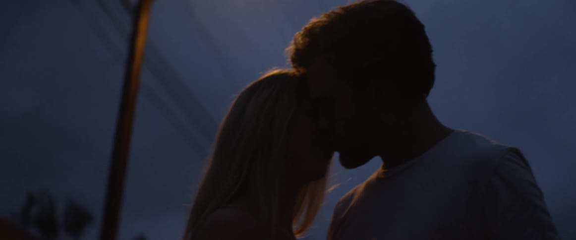 A young couple kisses passionately at night