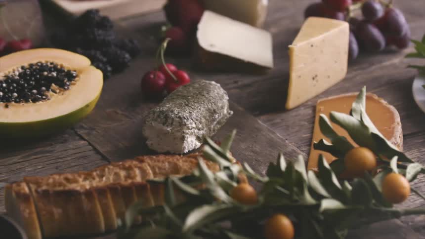 A variety of foods lie randomly scattered atop a wooden table