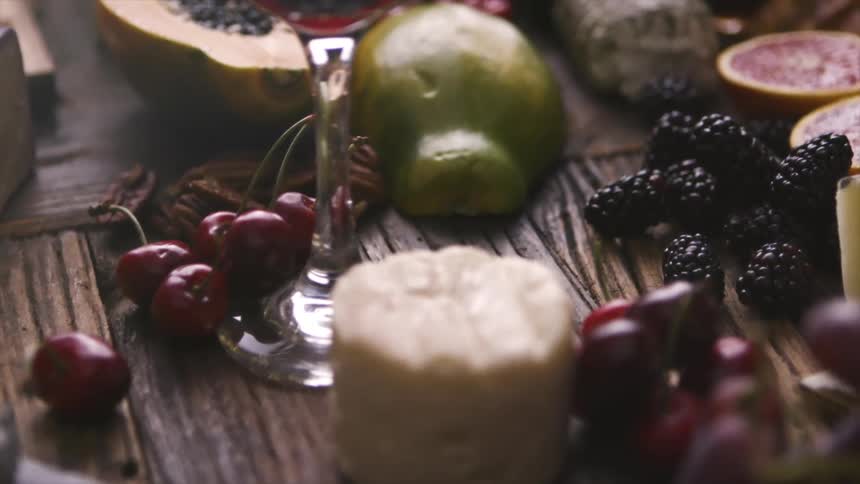 A large spread of food with cheese fruit bread and various spreads