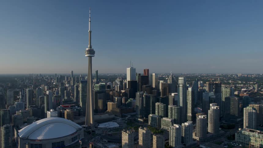 Aerial of a city scape featuring Toronto's CN Tower and Roger's Center Stadium