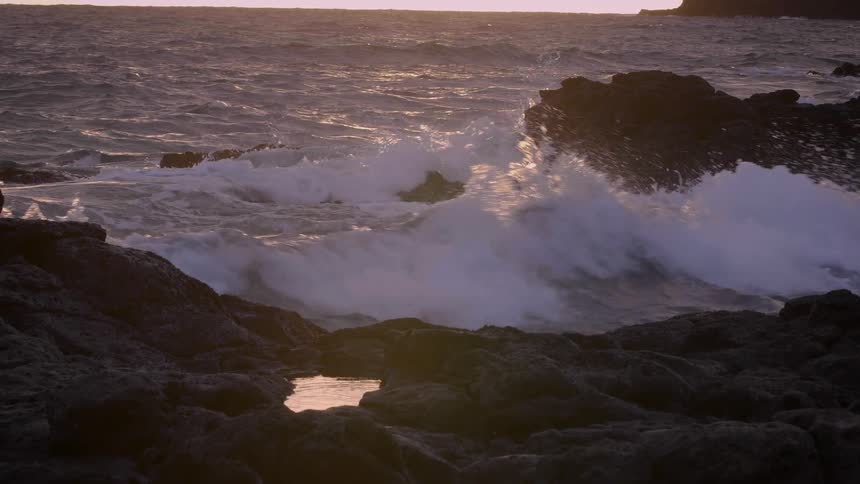 Water waves crashing onto rocks on the coast