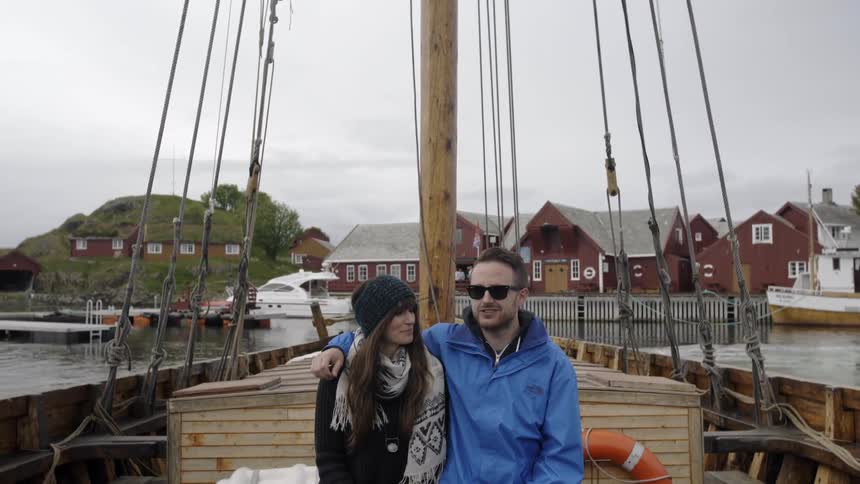 A couple sitting on a boat as it travels away from shore