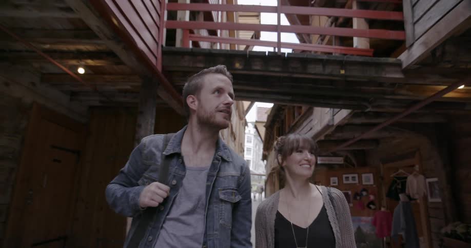A man and women walk down an alley on a cloudy day