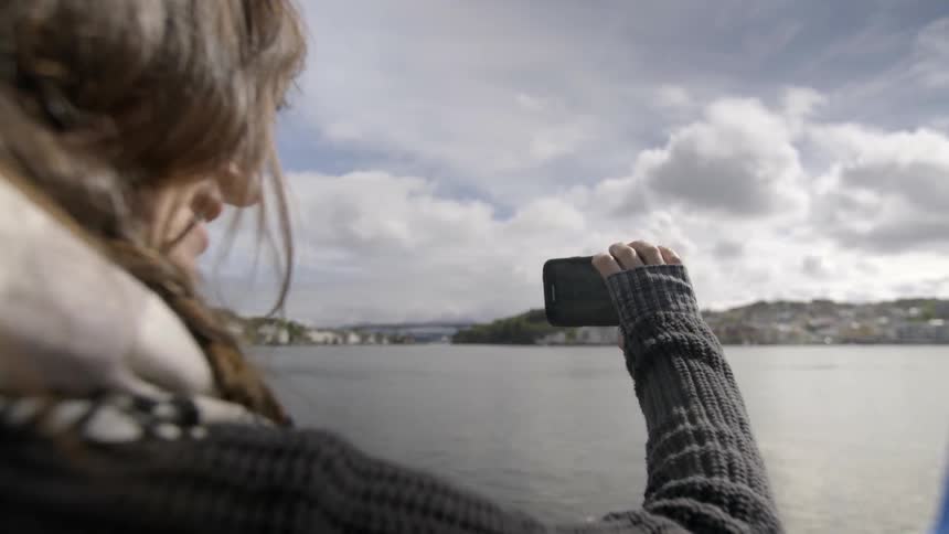 A woman is recording with a camera as a bird flies by