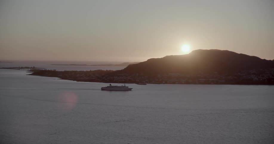 A boat travelling near the coast during sunset