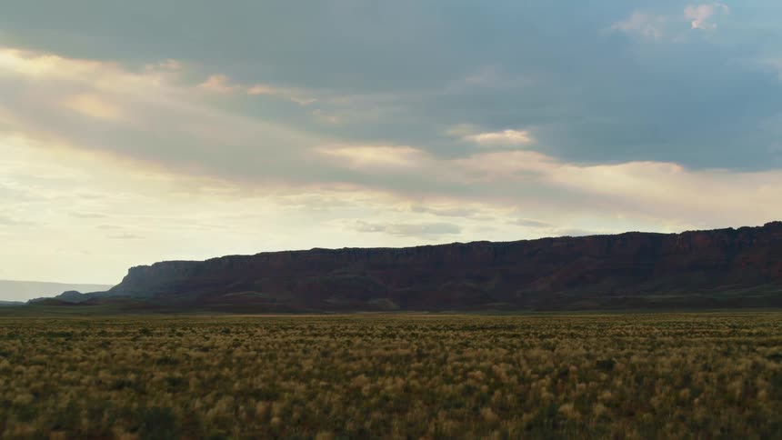 An open field with mountains in the distance in nature