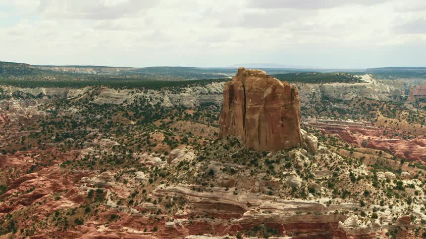A tall butte looming over the badlands during the day