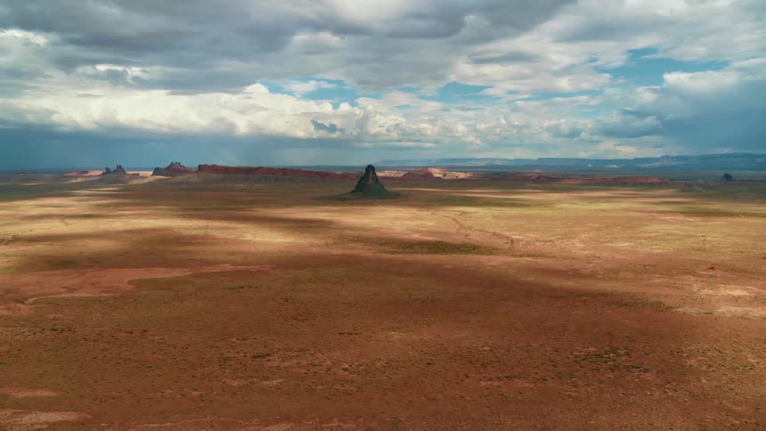 A mesa in a vast shrubland on a bright day