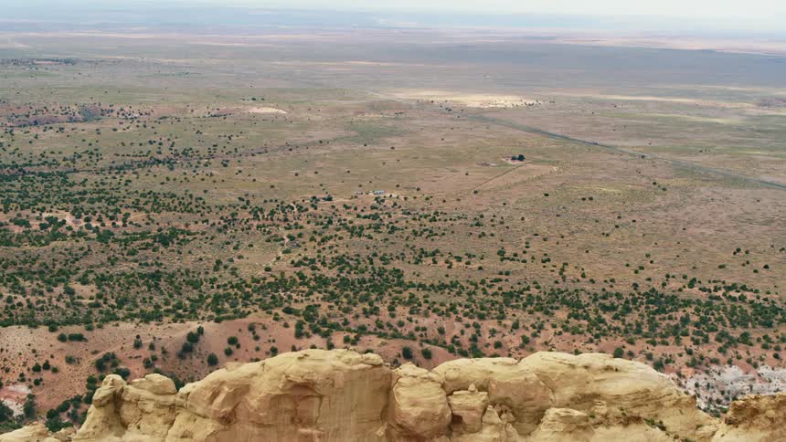 Flying over a large rocky hill and revealing a valley