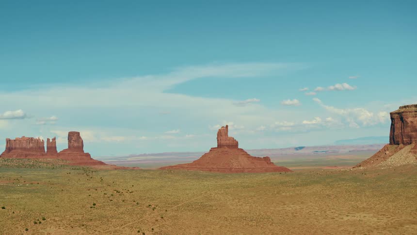 A desert with cliffs and plateaus with the sky and clouds in the background