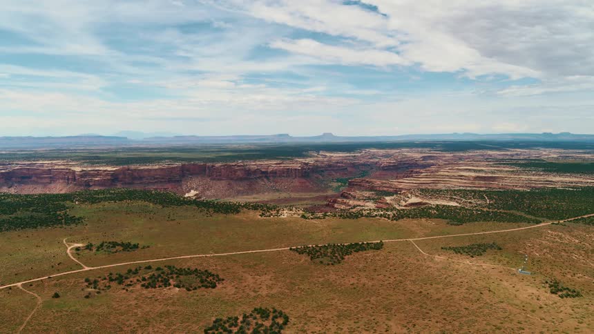 An aerial view of a field with badlands behind it