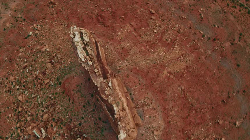 An aerial view of a tall red rock formation in nature