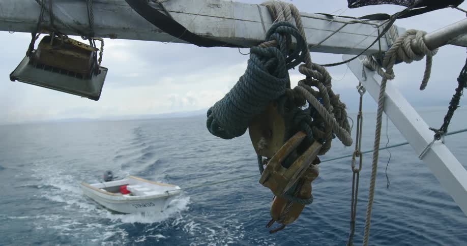 Small boat being towed on open water