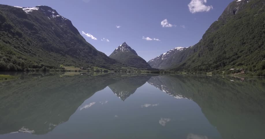 A man and a woman stand in front of a mountain lake